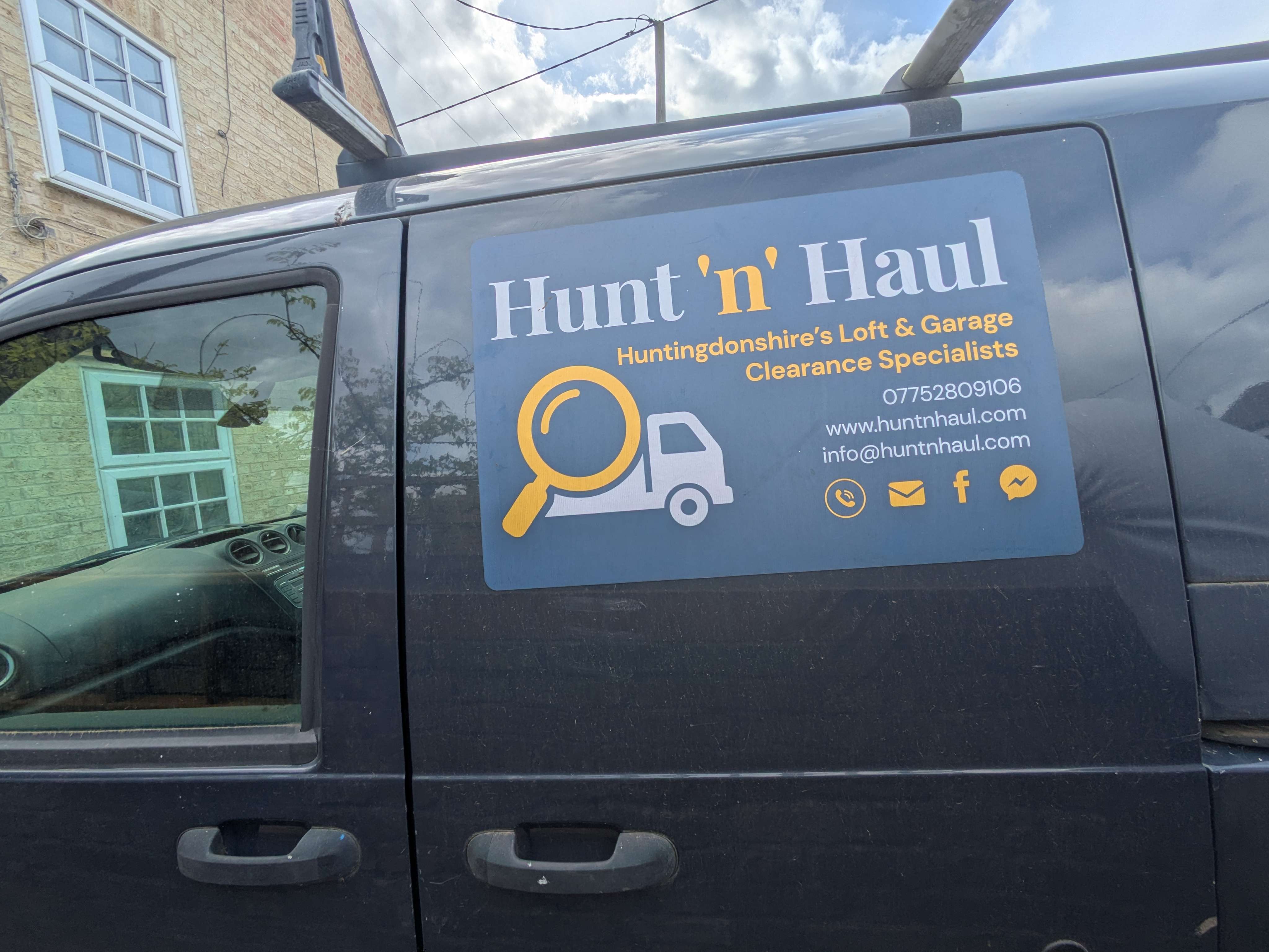 Close-up of the Hunt 'n' Haul branded van — magnetic side panel with magnifying-glass-and-van logo, contact details visible